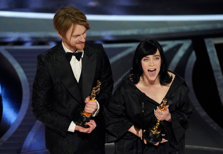 Billie Eilish, right, and Finneas O'Connell accept the award for best original song for "No Time To Die" at the Oscars on Sunday, March 27, 2022, at the Dolby Theatre in Los Angeles