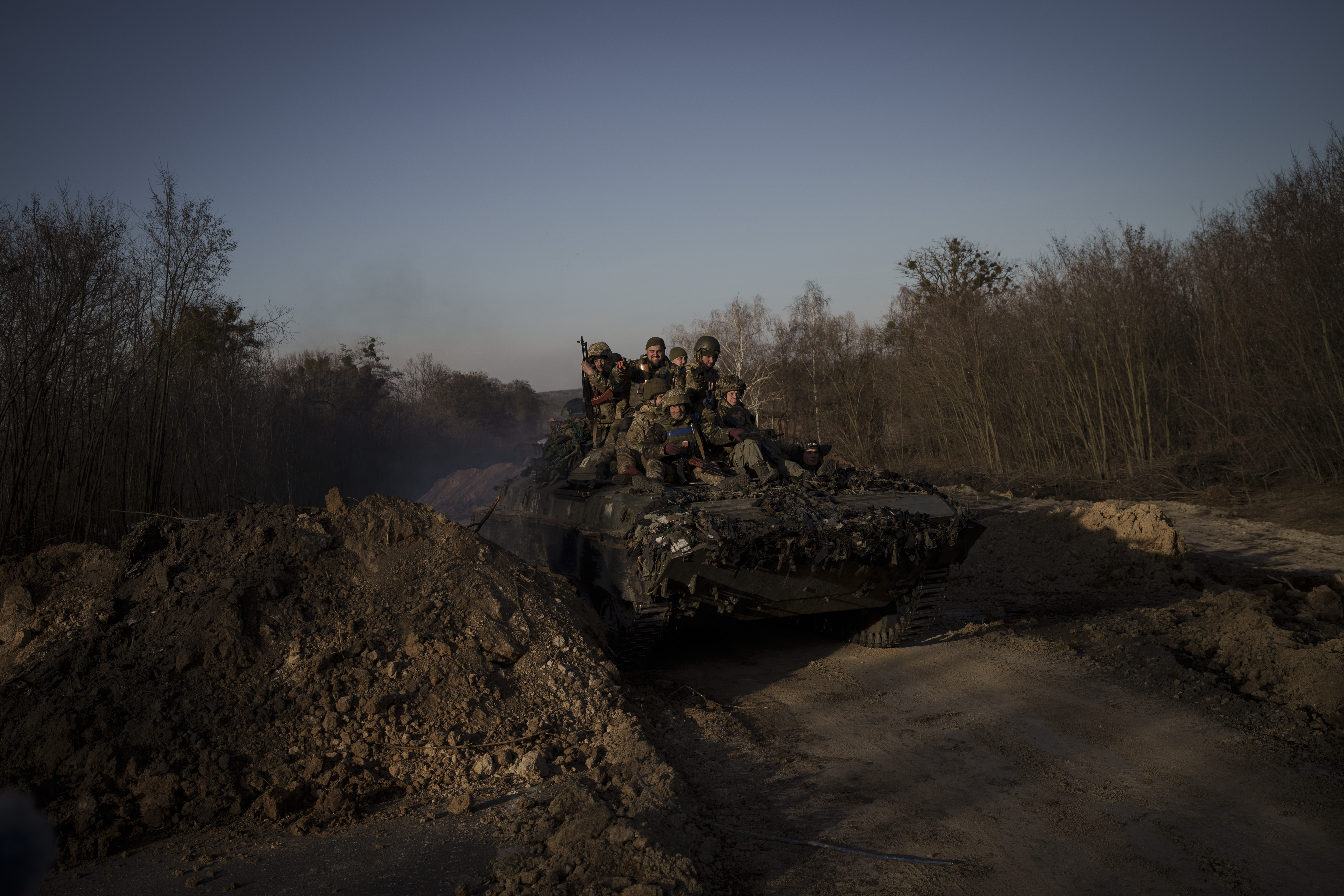 Ukrainian servicemen ride atop a tank near the town of Trostyanets, Ukraine