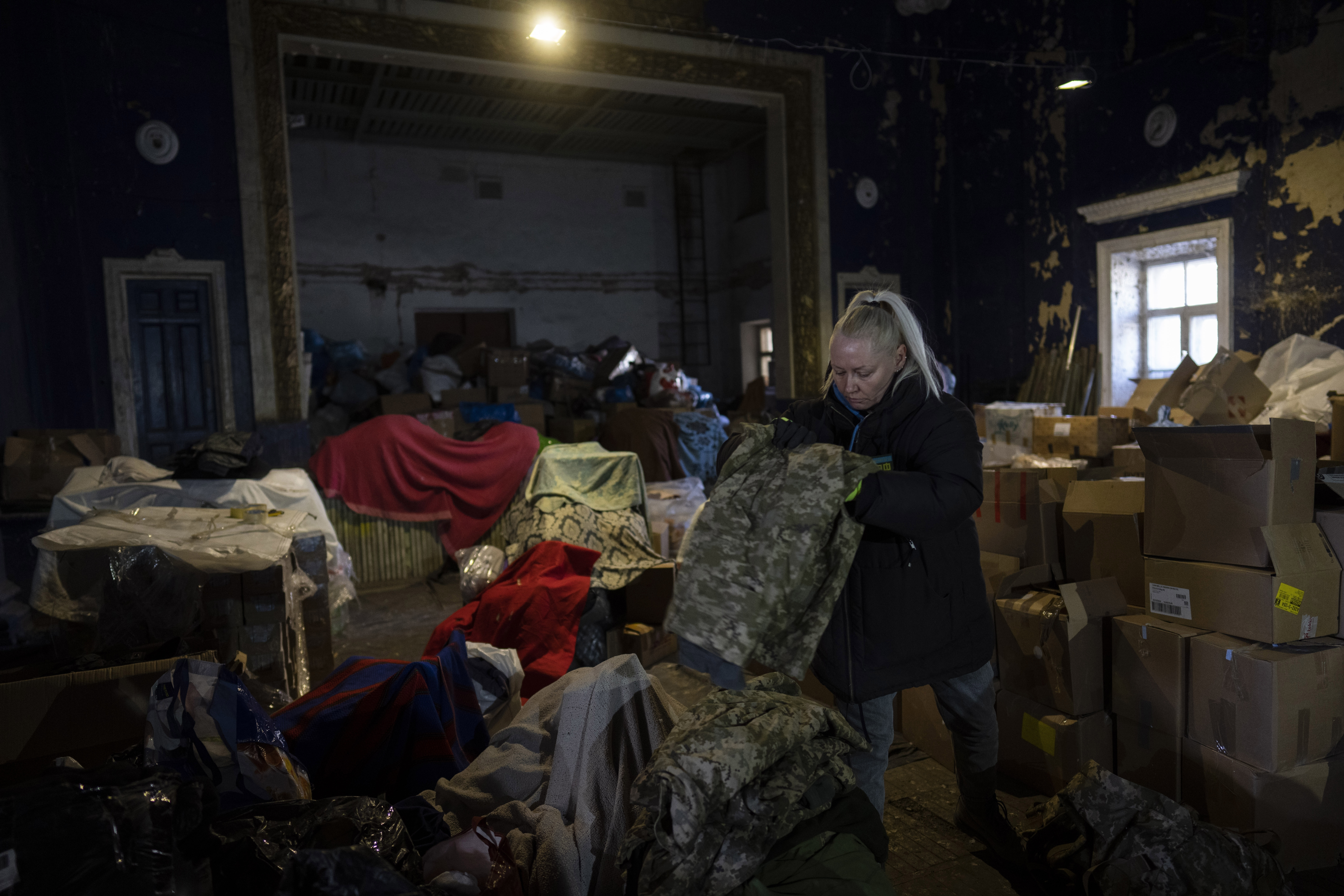 A volunteer folds army clothes inside a Ukrainian volunteer center in Mykolaiv