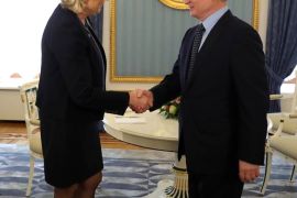 Le Pen and Putin shake hands before a meeting in Moscow in 2017