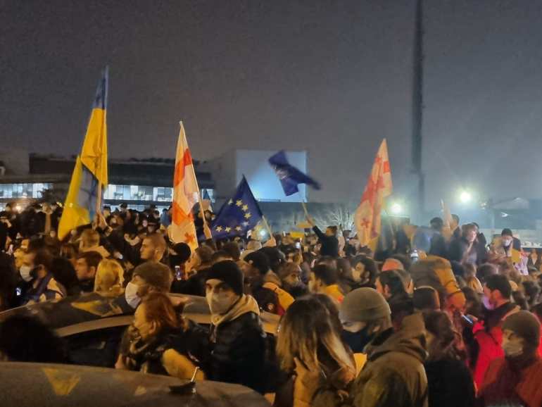 Protesters hold flags of Ukraine, Georgia and the EU