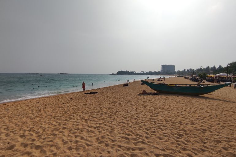 An almost empty beach with a small boat in Colombo, Sri Lanka