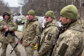 A screen shot of a video shows Ukrainian civilian volunteers armed and dressed in camouflage