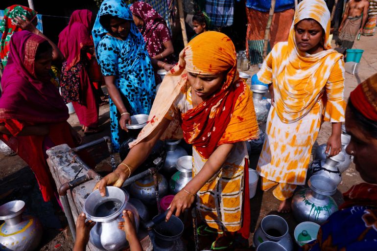 Slum dwellers gather to collect water from a common water tap in the afternoon at a slum as they don’t have a direct water line to their shelter in Dhaka, Bangladesh