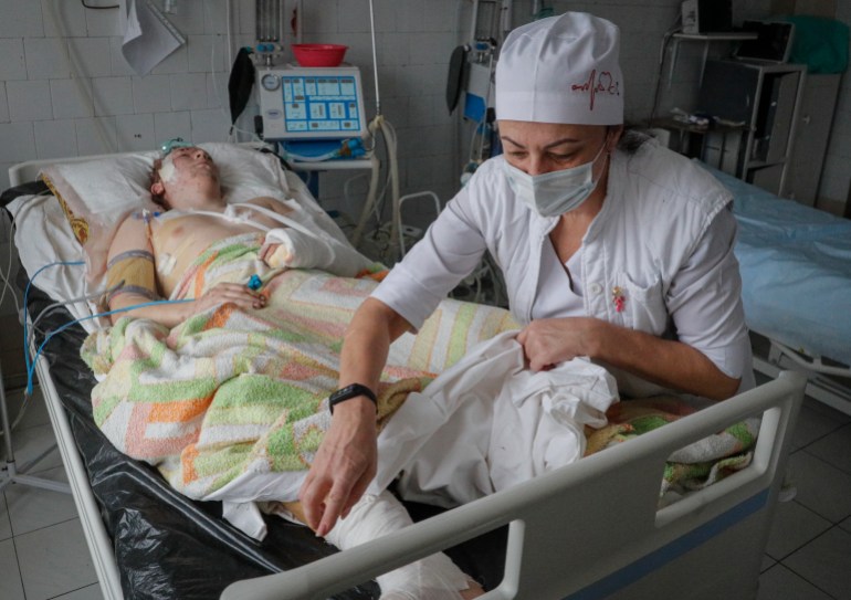 A nurse cares for a wounded soldier in a hospital near Kyiv