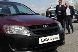 Russian Prime Minister Vladimir Putin, right, approaches a new model of Russian Lada-Granta car during his visit to "AvtoVaz" automobile plant in Tolyatti
