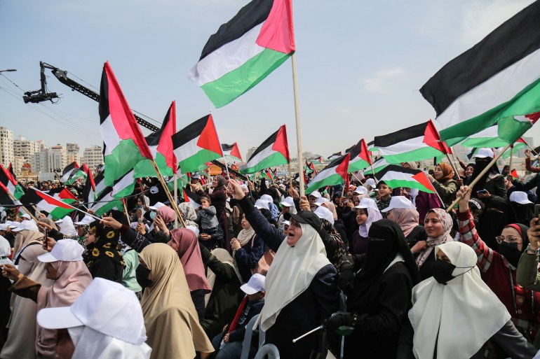Women wave Palestinian flags in land day