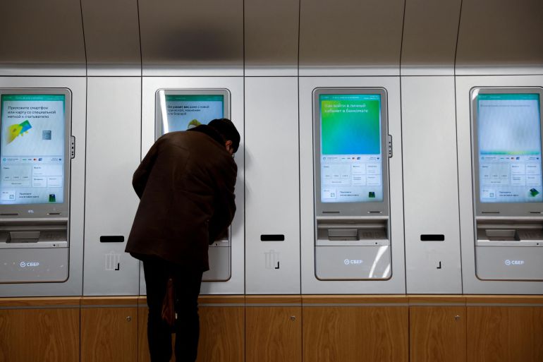 A man uses an ATM machine in an office of the Russian largest lender Sberbank in Moscow, Russia