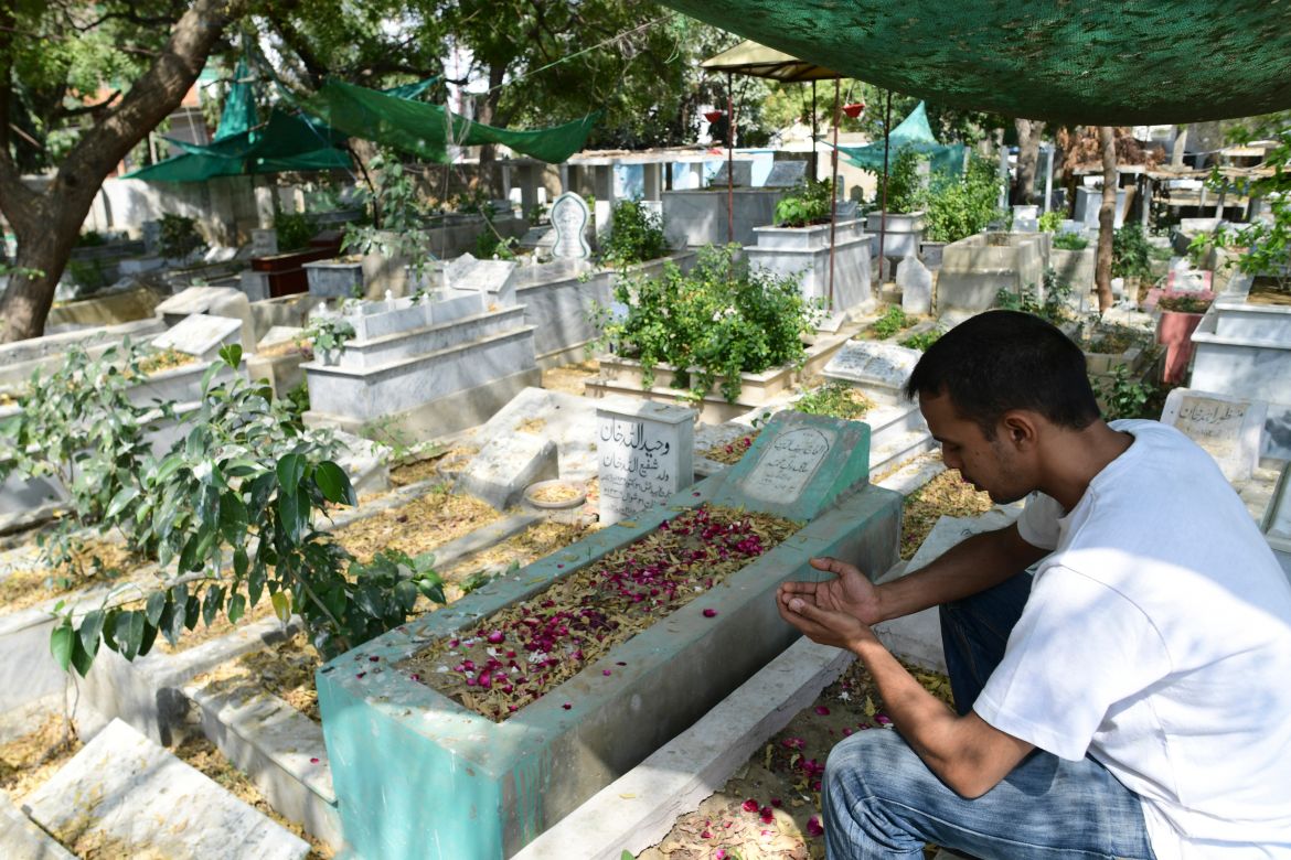 Muhammad Abdullah Saif offers prayers near his father's grave at the Tariq Road graveyard