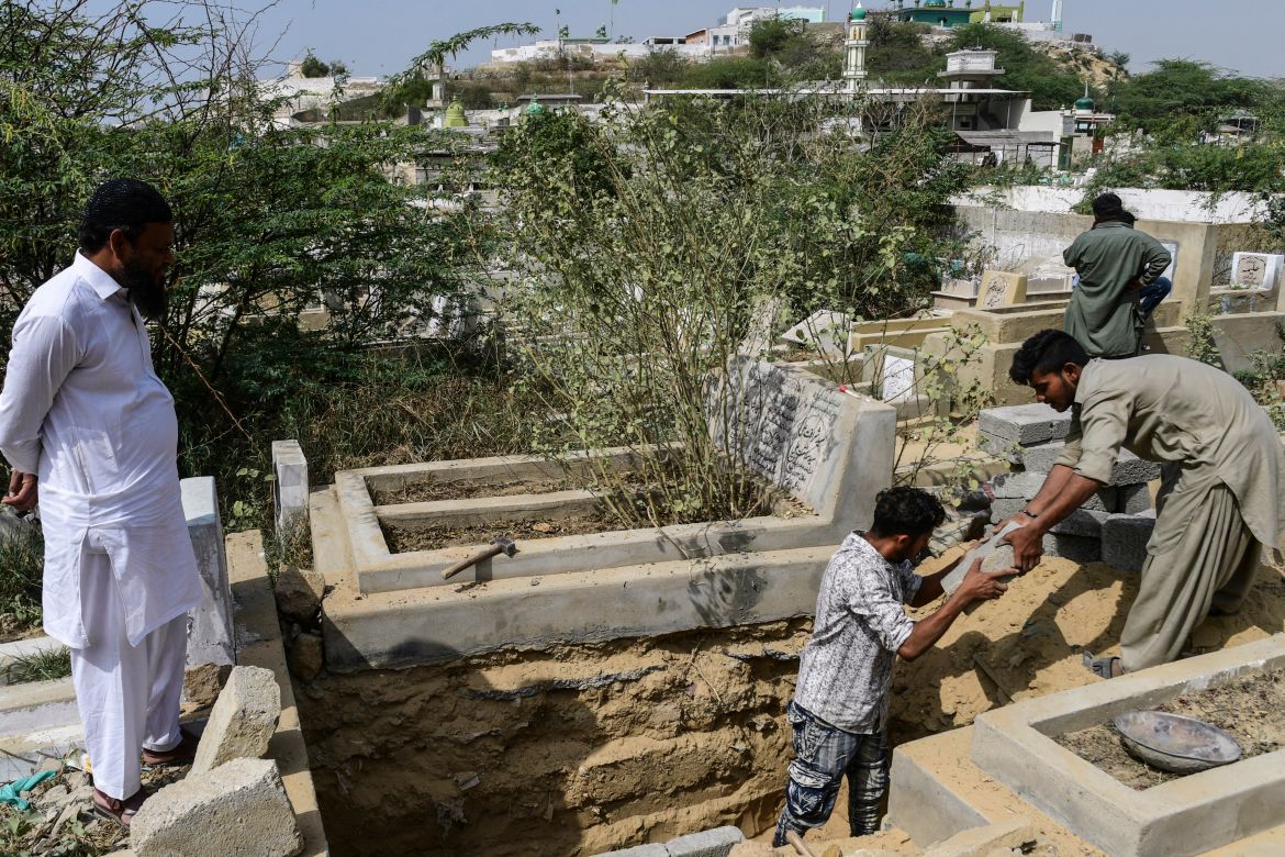 gravediggers make a new grave at the Korangi graveyard