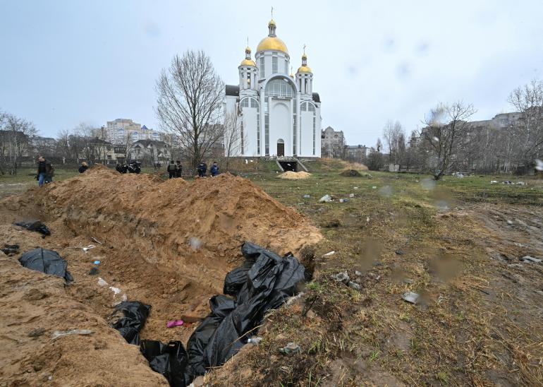 A mass grave is seen behind a church in the town of Bucha