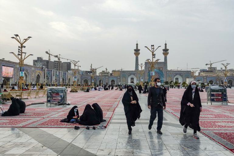 Shia Muslim worshippers walk through the courtyard of Imam Reza shrine.