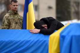 The mother of Ukrainian soldier Lubomyr Hudzeliak, who was killed during Russia's invasion of Ukraine, mourns over his flag-draped coffin during his funeral at the Lychakiv cemetery, in the western Ukrainian city of Lviv
