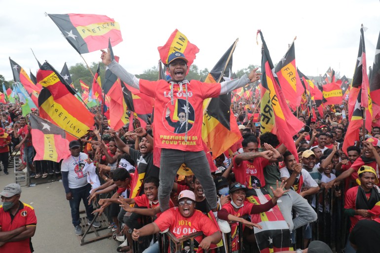 Fretilin party supporters shouting slogans and waving the party's red, gold and black flag at a rally in March