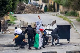 Palestinian protesters throw stones at Israeli forces during clashes in the village of Burqa in the north of the occupied West Bank