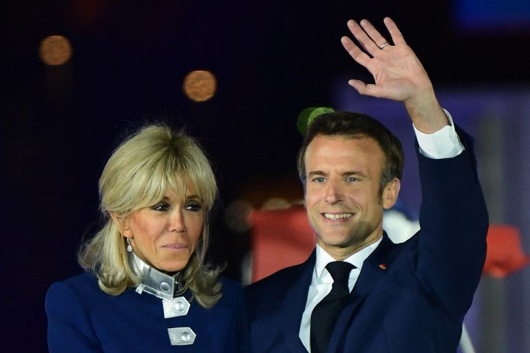 French President and La Republique en Marche (LREM) party candidate for re-election Emmanuel Macron and his wife Brigitte Macron celebrate after his victory in France's presidential election, at the Champ de Mars in Paris, on April 24, 2022.