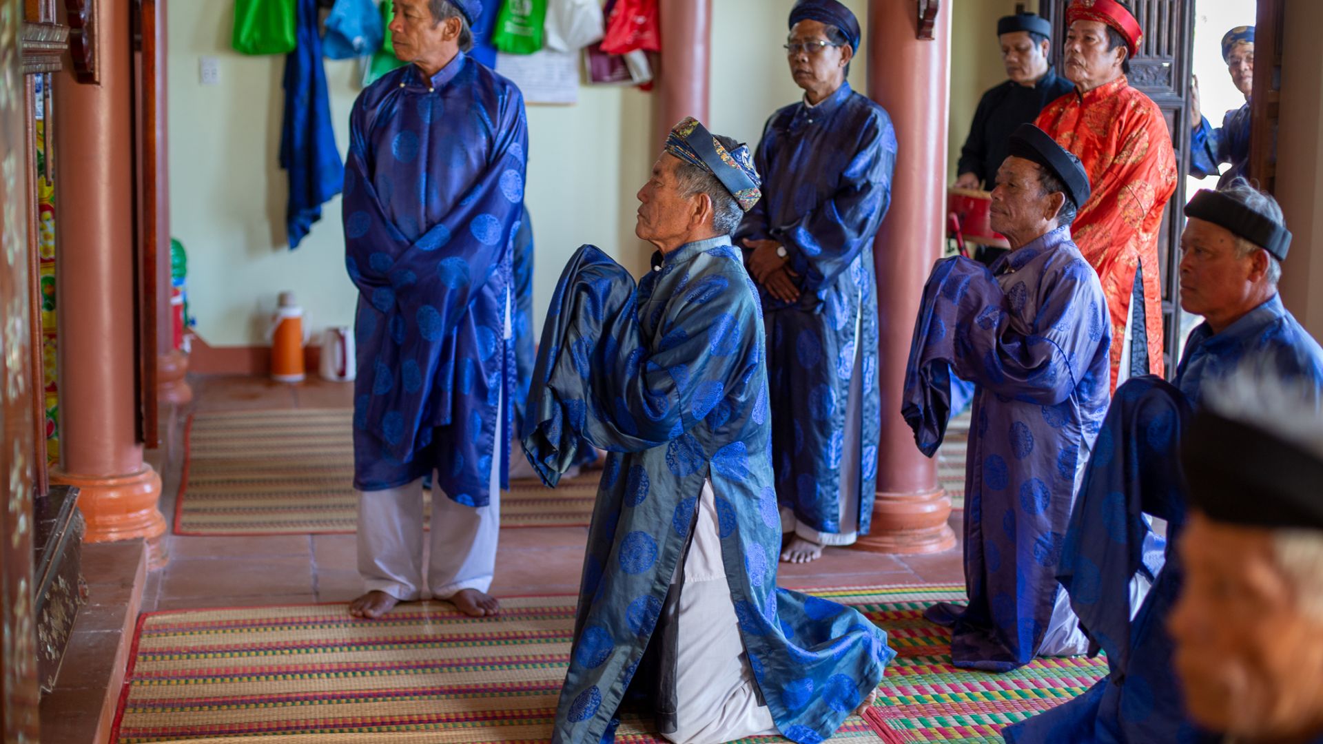 A photo of whale worshippers bowing and praying during a ceremony.