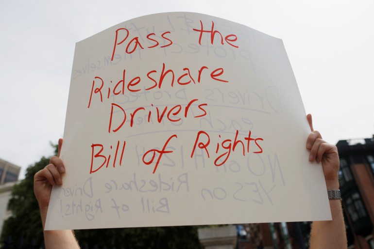 A protestor holds a sign reading “Pass the Rideshare Drivers Bill of Rights” at a demonstration in Boston, Massachusetts, US
