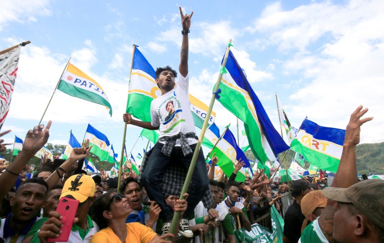 Supporters of former East Timor's leader and Nobel laureate Jose Ramos-Horta wave flags and cheer at a rally during the first round of the presidential election