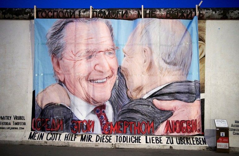 Former German Chancellor Gerhard Schroeder and Russian President Vladimir Putin are depicted in this graffiti exchanging a kiss at the East Side Gallery in Berlin, Germany April 2, 2022. 