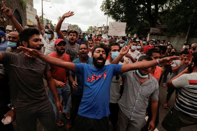 People shout slogans against Sri Lankan President Gotabaya Rajapaksa in a residential area of Colombo after the government imposed a curfew