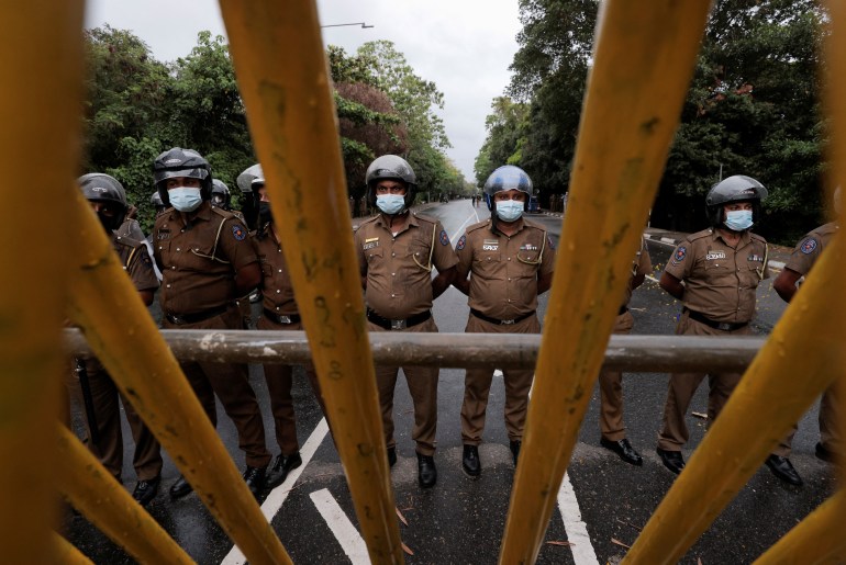 Sri Lanka police officers stand guard on a road leading to the parliament