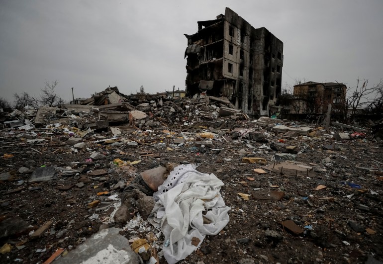 The corpse of a civilian is seen near destroyed residential buildings in Borodyanka