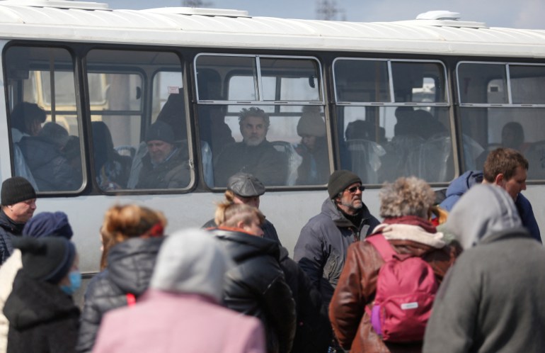 Evacuees are seen on a bus as they leave Mariupol