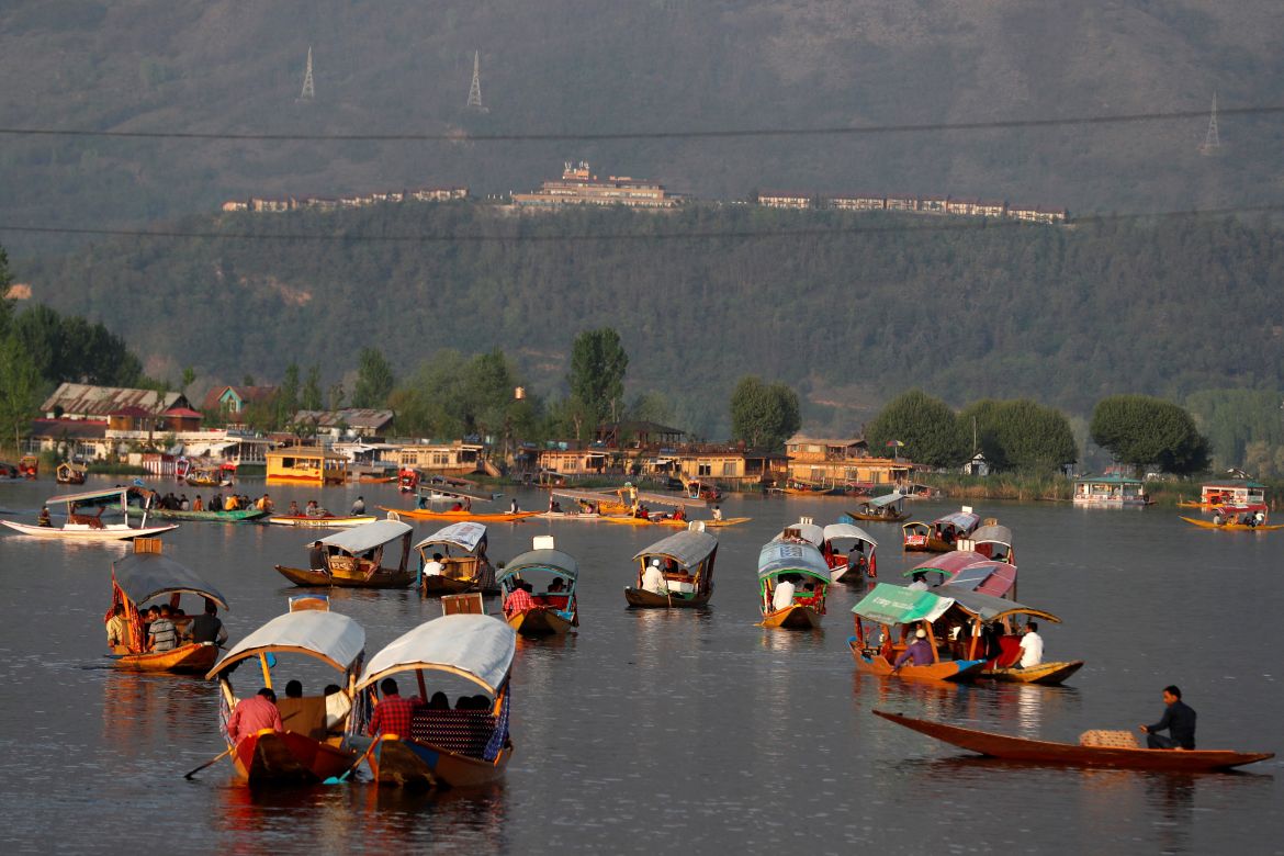 Tourists ride "Shikaras" or boats in the waters of Dal Lake