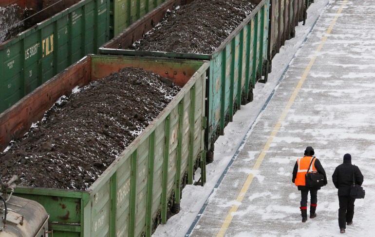 Men are seen walking along wagons oaded with coal at the Zlobino railway station in Russia's Siberian city of Krasnoyarsk