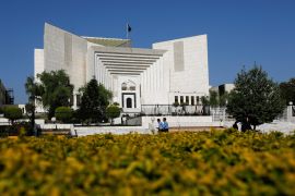 Police officers walk past the Supreme Court of Pakistan building, in Islamabad