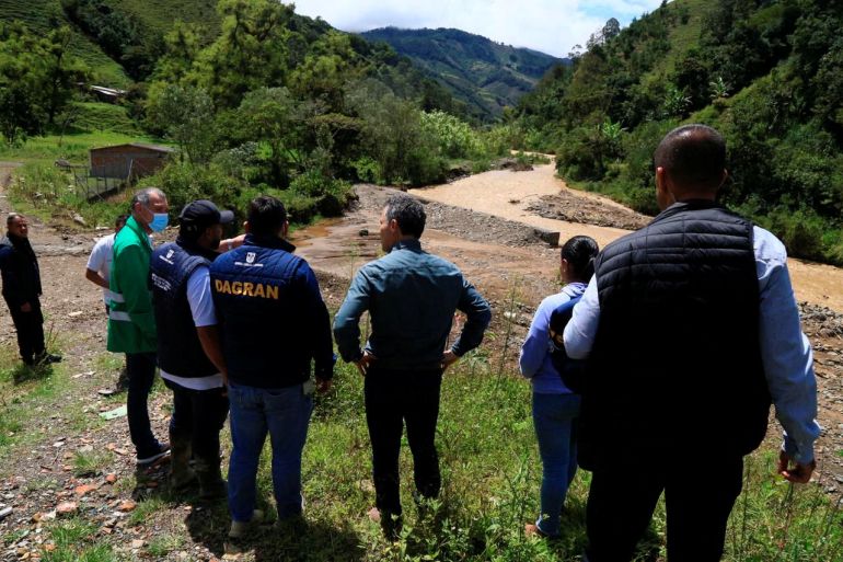 Officials look out at the site of flash flooding in Colombia