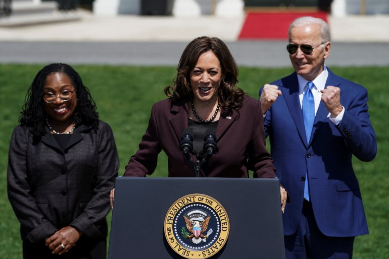 Ketanji Brown Jackson, Kamala Harris and Joe Biden stand at a podium at the White House