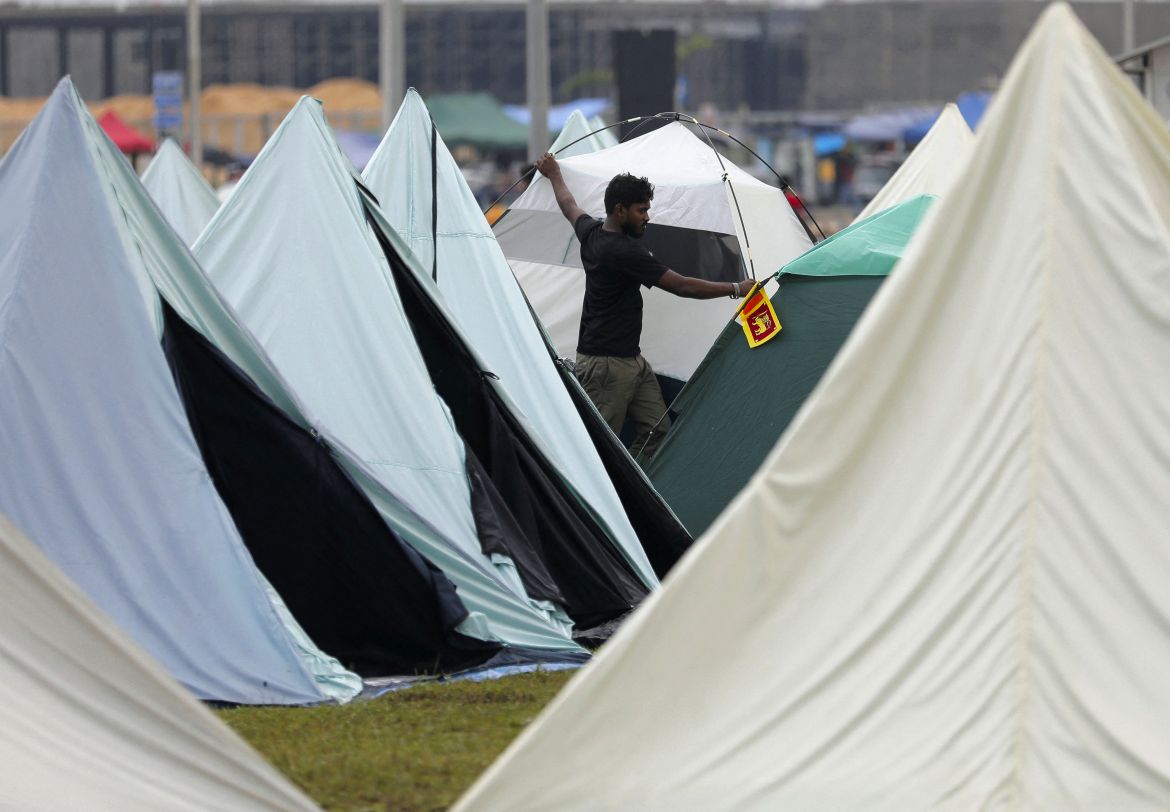 A demonstrator carries a tent to find a place for it inside a protest area