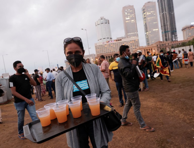 A person serves beverages to other demonstrators inside a protest area, dubbed the Gota-Go village, 