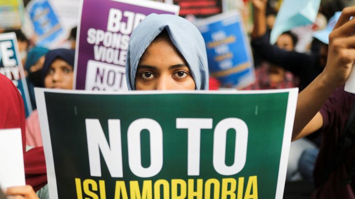 Young women holds a sign that reads "no to islamophobia".