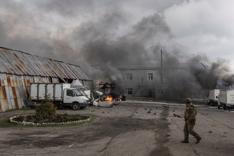A Ukrainian soldier stands in front of a building after it was hit by shelling in Lysychansk, Luhansk region, Ukraine,
