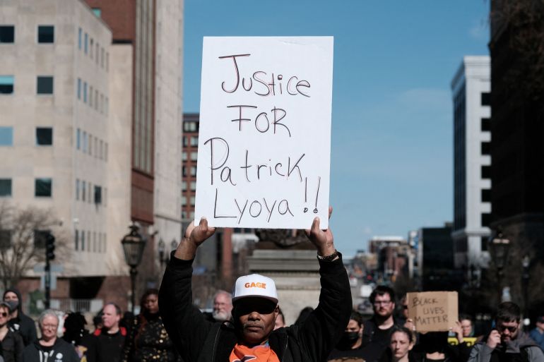 A protester holds a sign reading Justice for Patrick Lyoya