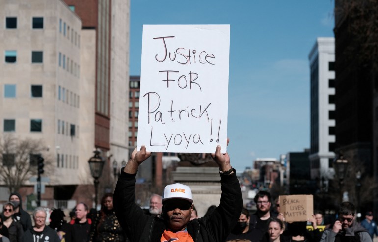 A protester holds a sign reading Justice for Patrick Lyoya