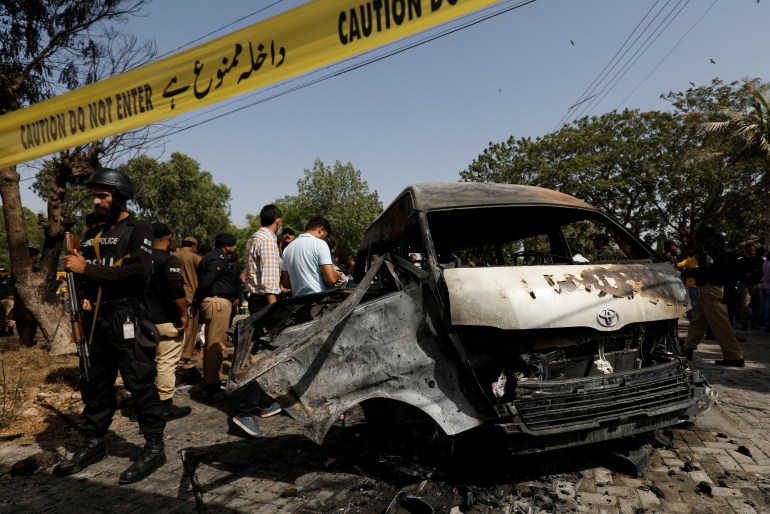 Pakistani officers inspect a passenger van after a suicide blast .