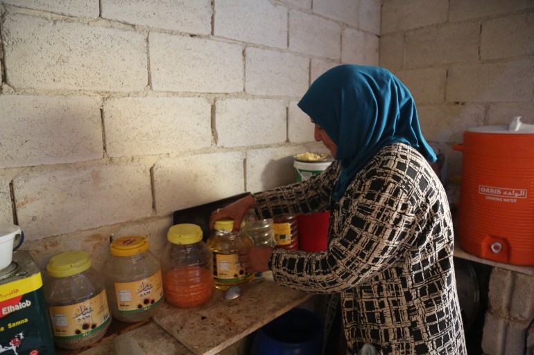 Woman in makeshift kitchen with jars of food supplies