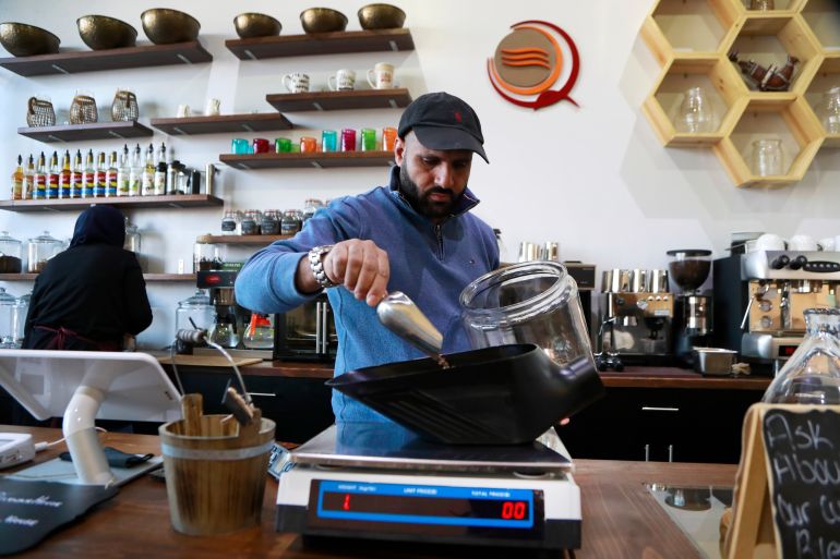 Ibrahim Alhasbani, owner of Qahwah House in Dearborn, Michigan, measures coffee