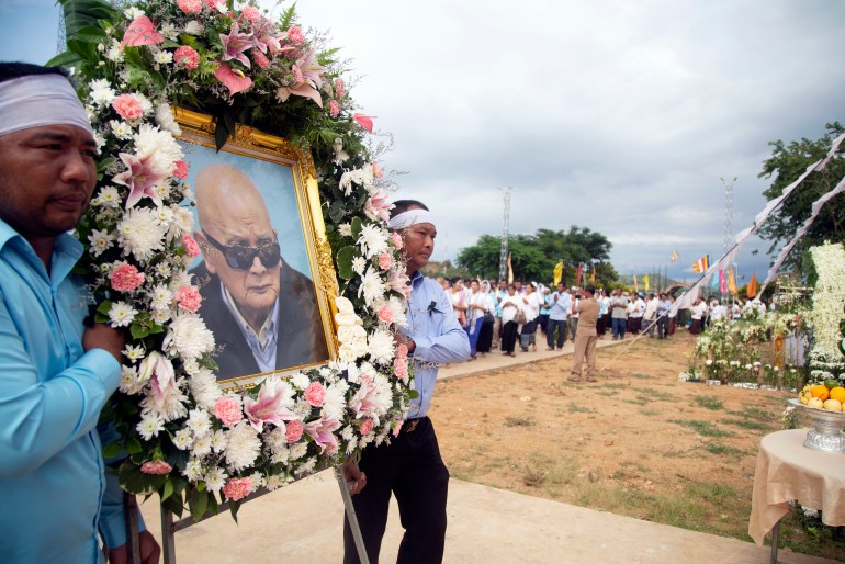 Relatives carry a portrait surrounded by fresh flowers of former Khmer Rouge's chief ideologist and No. 2 leader, Nuon Chea, during his funeral procession in 2019 