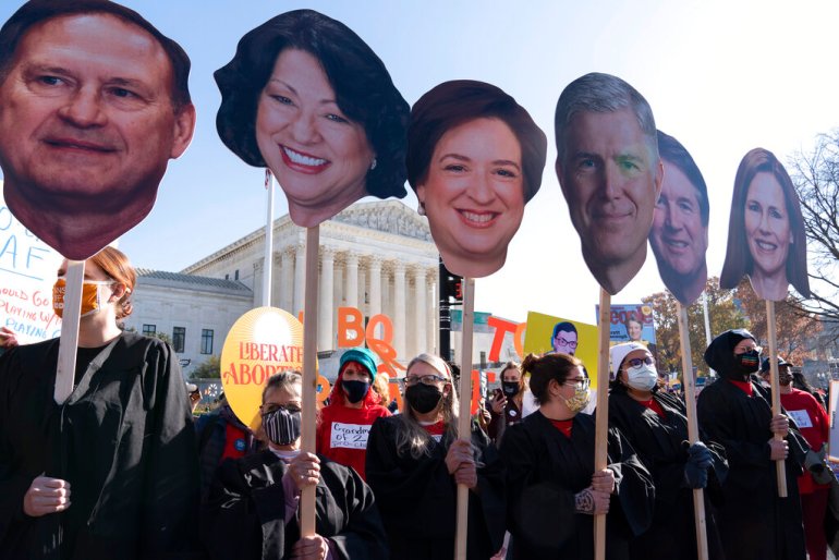Abortion rights advocates holding cardboard cutouts of the Supreme Court Justices, demonstrate in front of the U.S. Supreme Court.
