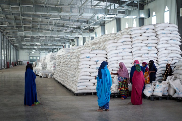 Workers clean the floor as sacks of food earmarked for the Tigray and Afar regions sits in piles 