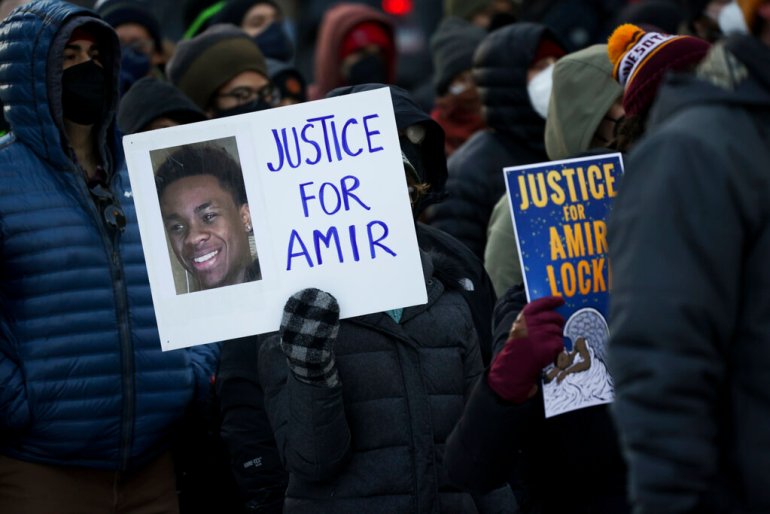 A protester holds a sign demanding justice for Amir Locke at a rally in Minneapolis.
