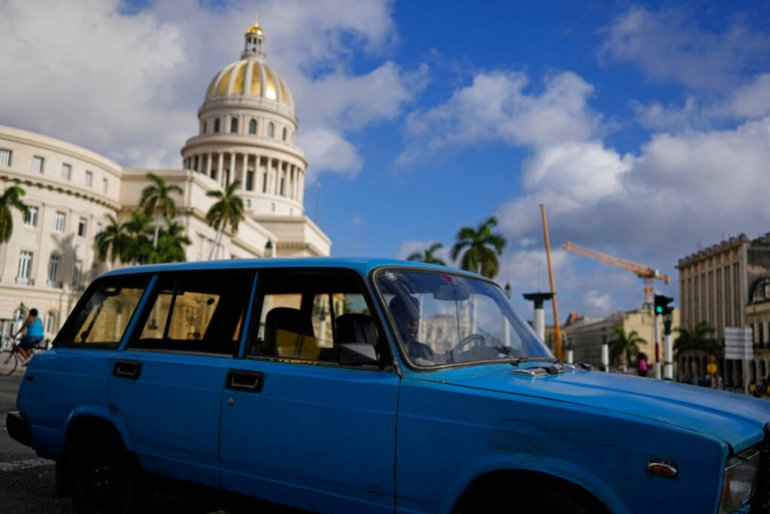 A driver navigates a vintage, Russian-made Lada station-wagon past the Capitol in Havana, Cuba