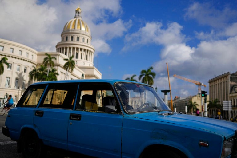 A driver navigates a vintage, Russian-made Lada station-wagon past the Capitol in Havana, Cuba