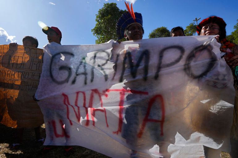 Munduruku Indigenous people carry a banner with text written in Portuguese that reads "Mining Kills," during the March for the Demarcation of Indigenous Lands, in Brasilia, Brazil.