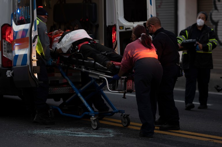 First responders give medical assistance to a driver on R.H. Tood Avenue after a car crash near an intersection during a blackout in San Juan, Puerto Rico